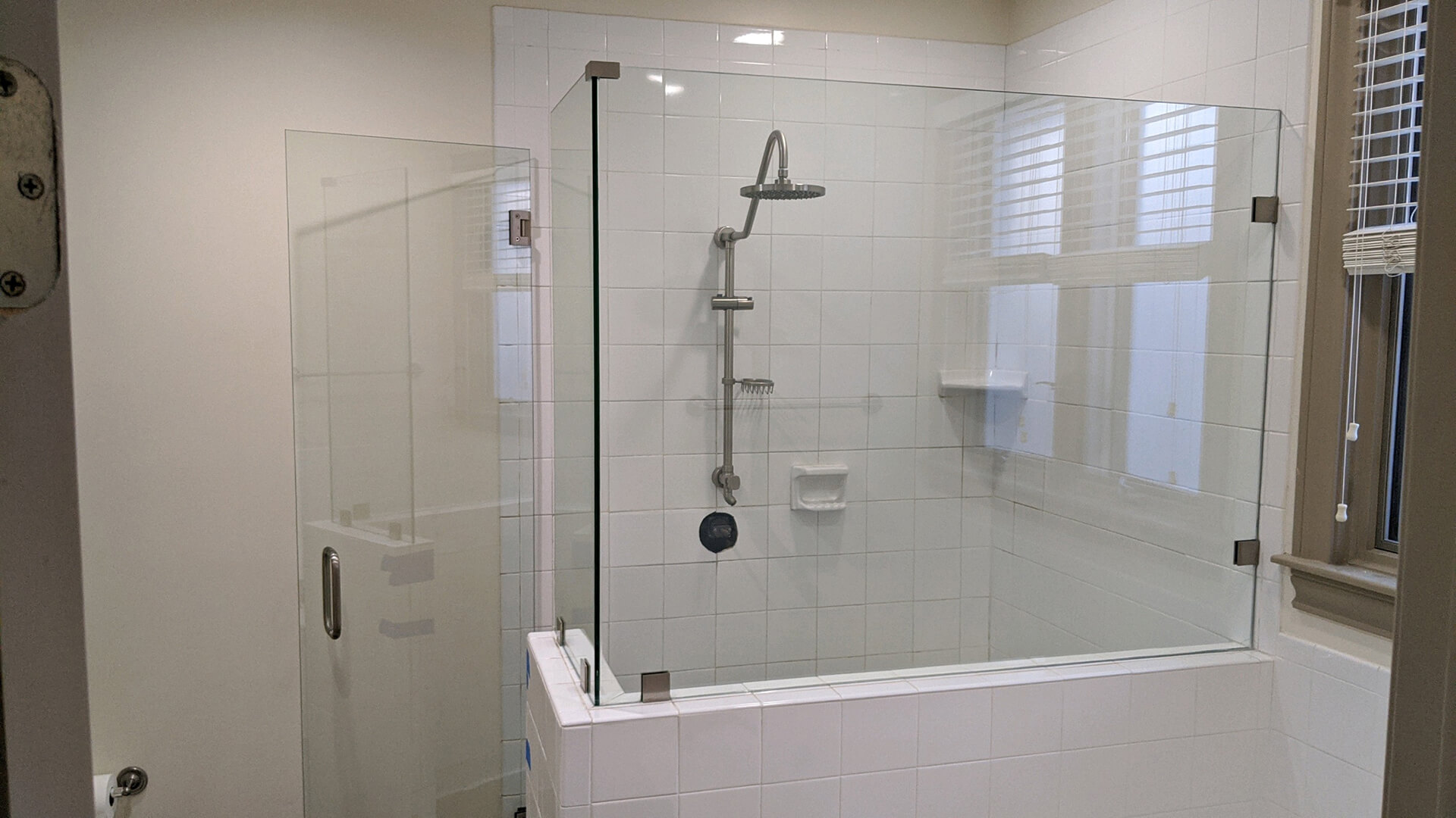 Frameless glass shower door with a rain shower head and white subway tile, installed by Door Pro Plus for a Hill Country bathroom remodel